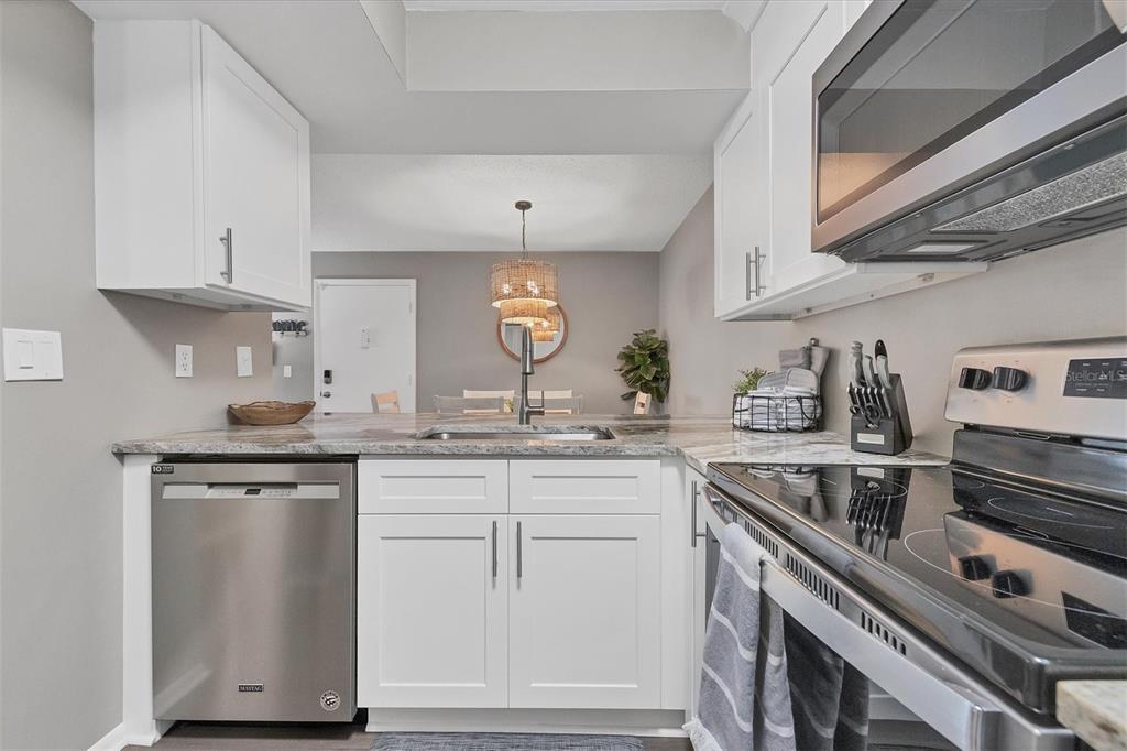 3239 South Beneva Road, Unit 101 Sarasota, FL 34232 - Photo 15 of 37 a kitchen with cabinets wooden floor and stainless steel appliances