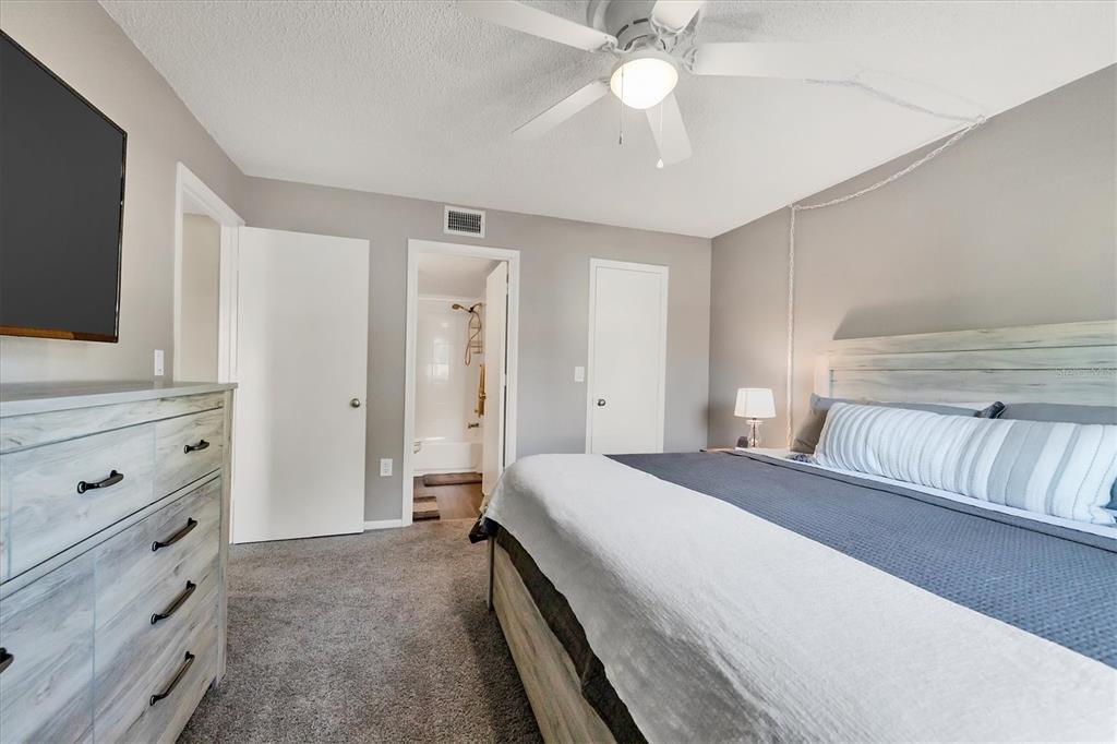 3239 South Beneva Road, Unit 101 Sarasota, FL 34232 - Photo 18 of 37 a bedroom with a large bed and a flat tv screen on dresser