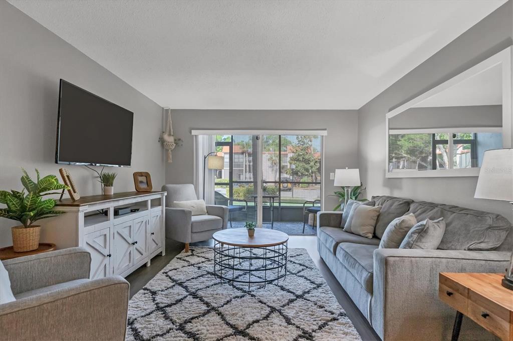 3239 South Beneva Road, Unit 101 Sarasota, FL 34232 - Photo 3 of 37 a living room with furniture and a flat screen tv