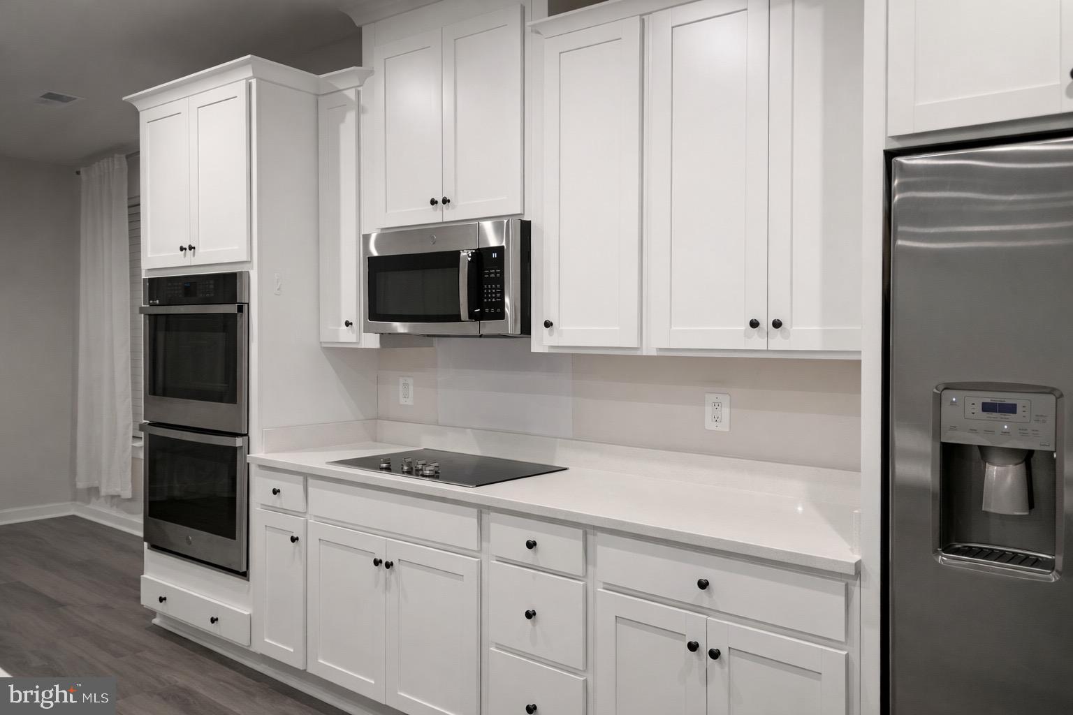 13695 Innovation Station Loop, Unit 77B Herndon, VA 20171 - Photo 2 of 11 a kitchen with granite countertop white cabinets and stainless steel appliances
