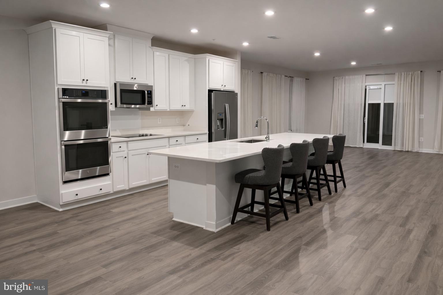 13695 Innovation Station Loop, Unit 77B Herndon, VA 20171 - Photo 3 of 11 a kitchen with stainless steel appliances a dining table chairs and refrigerator