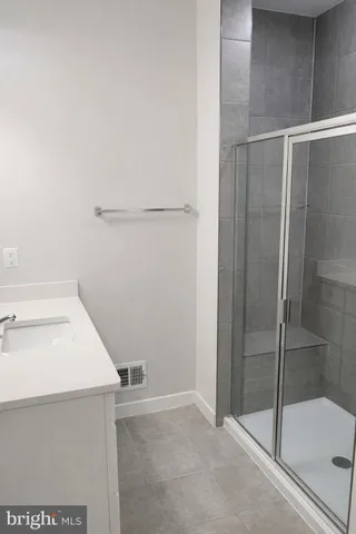 a bathroom with a granite countertop sink a toilet and shower