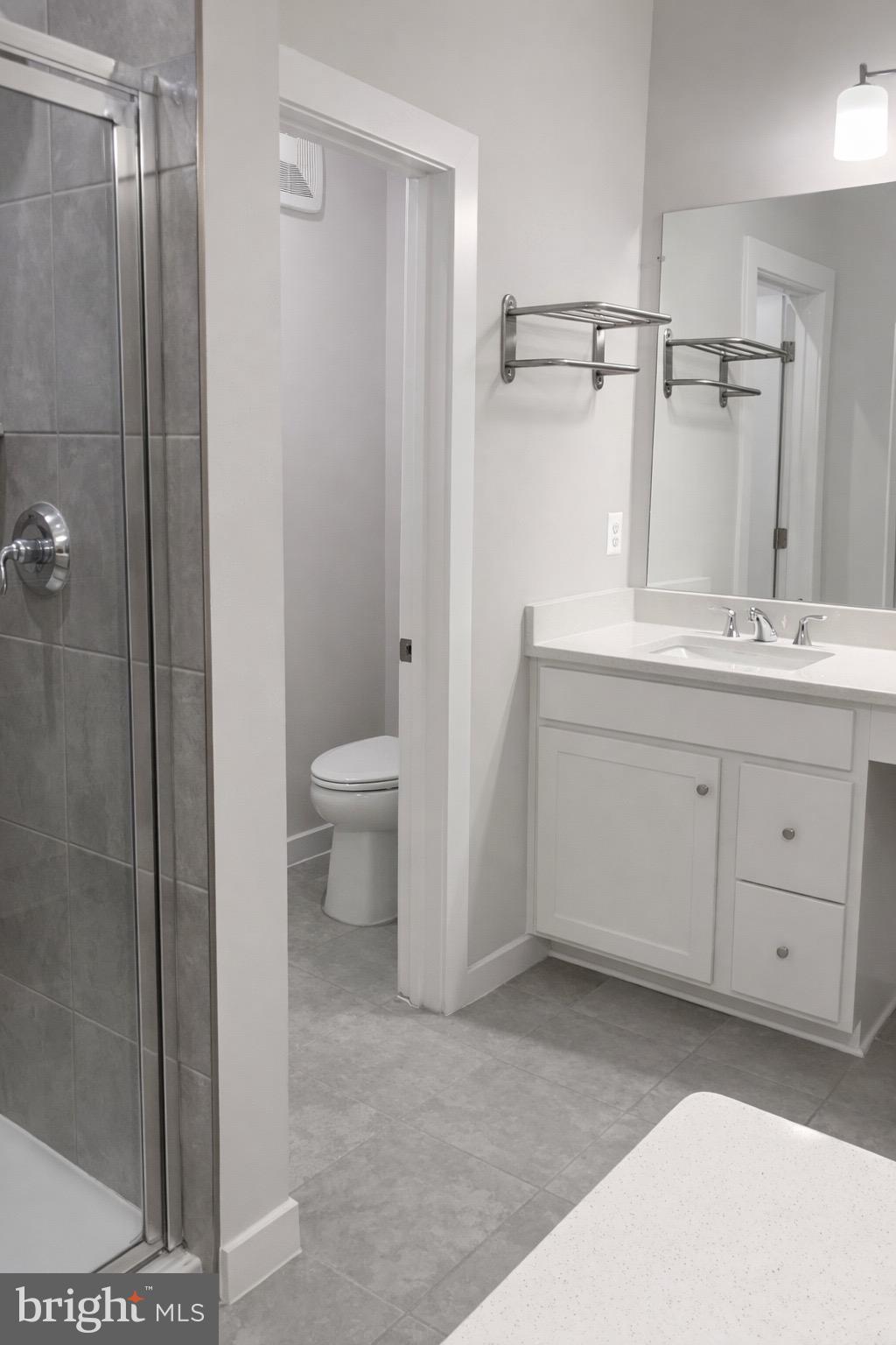 13695 Innovation Station Loop, Unit 77B Herndon, VA 20171 - Photo 8 of 11 a bathroom with a granite countertop sink a toilet and shower