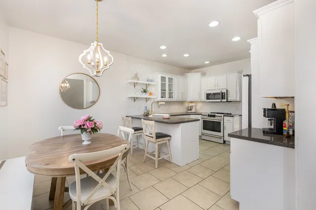 a kitchen with white cabinets and white appliances