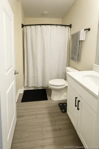 a bathroom with a sink a toilet a window and a shower