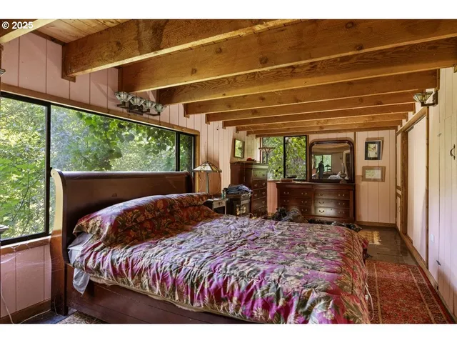 a bed sitting in a bedroom next to a window