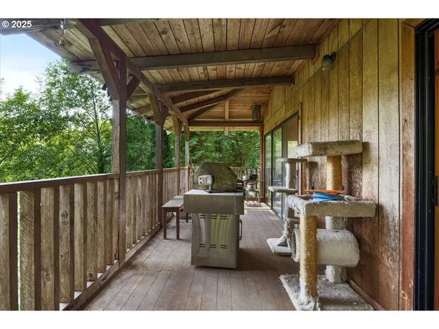 a view of a chairs and table in the patio next to a yard