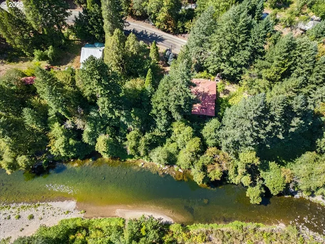 an aerial view of lake residential house with outdoor space and trees around