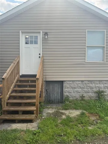 a view of a house with a yard and stairs