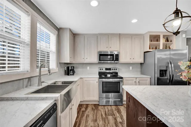 a kitchen with stainless steel appliances granite countertop a sink stove and refrigerator