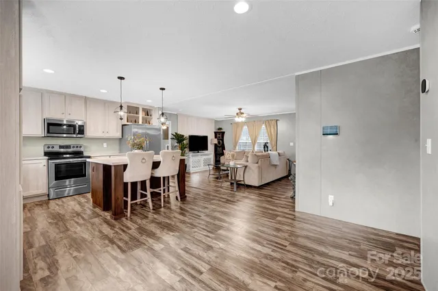a large white kitchen with lots of counter space and stainless steel appliances