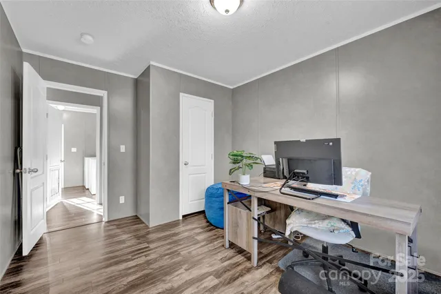 a view of a workspace with furniture and wooden floor