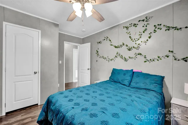 a bedroom with bed and wooden floor