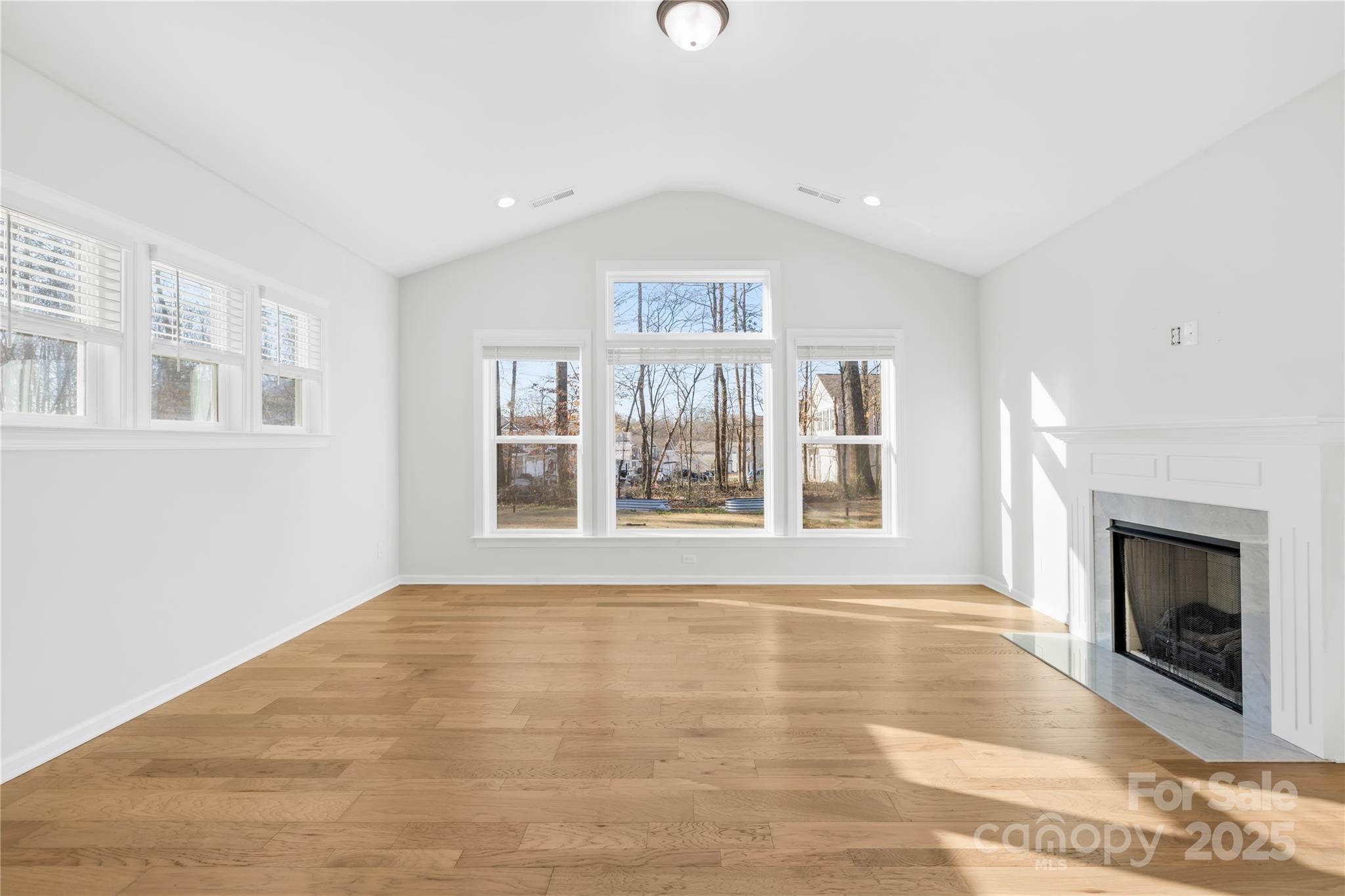 8005 Rolling Wheels Road Charlotte, NC 28215 - Photo 17 of 40 a view of an empty room with a fireplace and a window