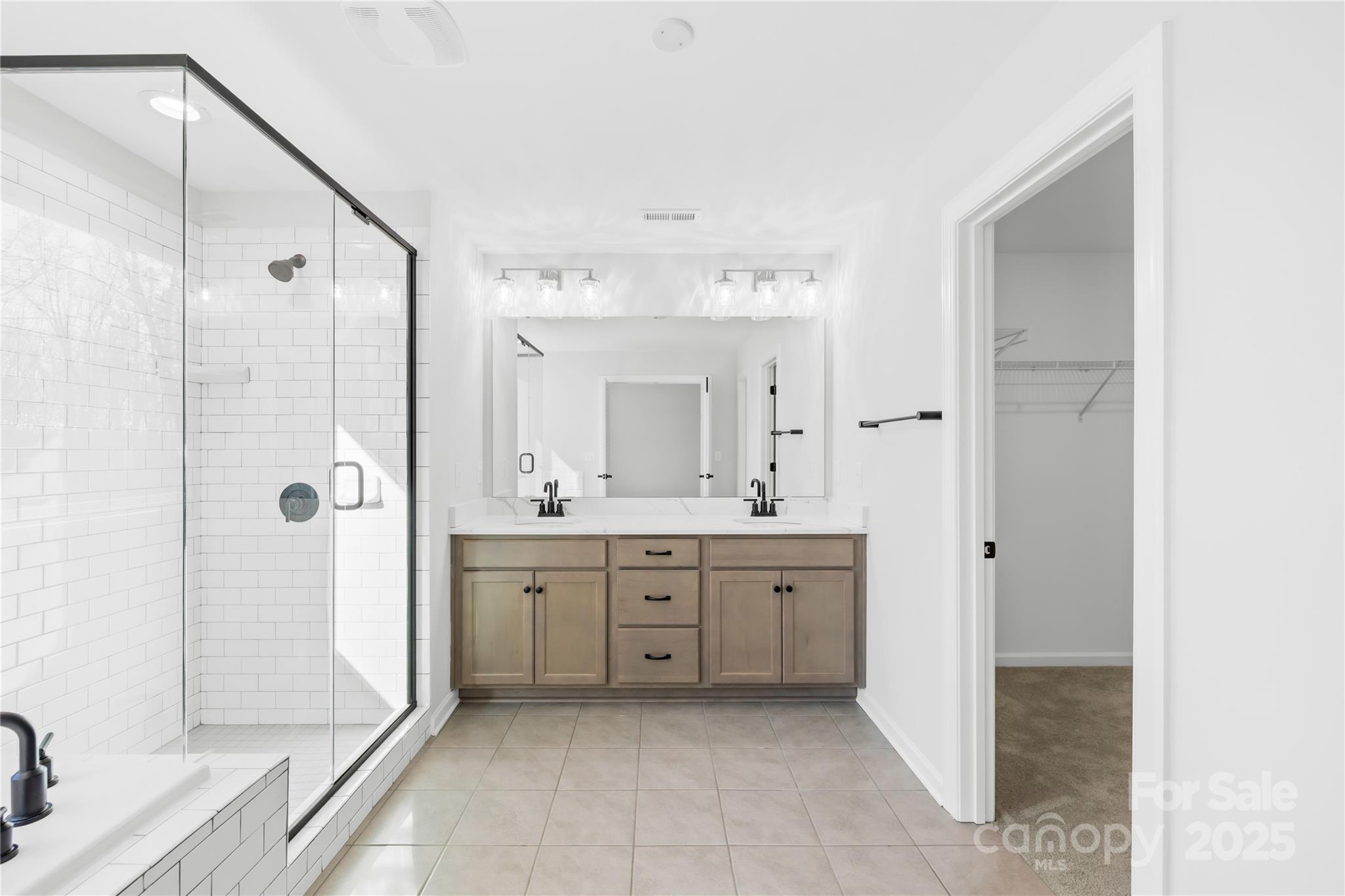 8005 Rolling Wheels Road Charlotte, NC 28215 - Photo 27 of 40 a spacious bathroom with a shower sink and mirror