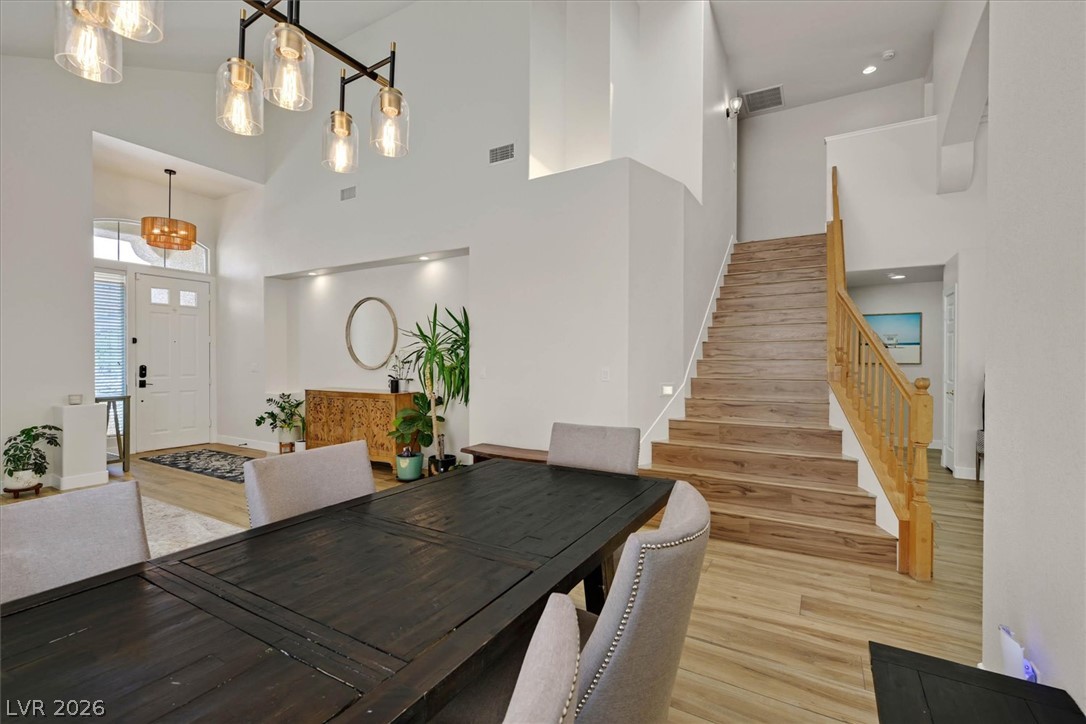 1259 Moon Vision Street Henderson, NV 89052 - Photo 22 of 53 An inviting entry and dining area features wood flooring and a grand staircase.