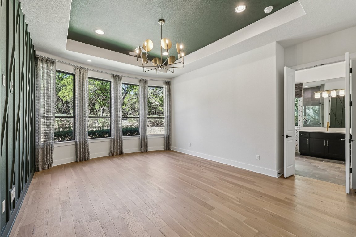 19316 Splendor Court Jonestown, TX 78645 - Photo 17 of 40 a view of a room with a chandelier and wooden floor