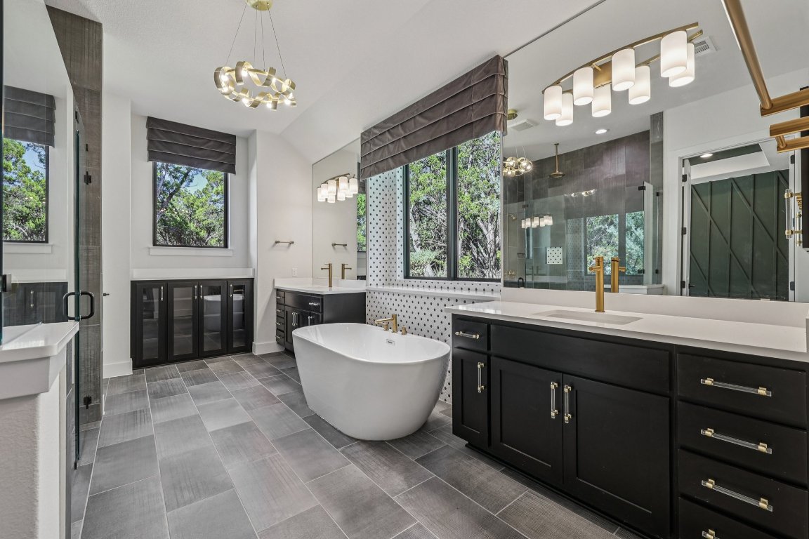 19316 Splendor Court Jonestown, TX 78645 - Photo 18 of 40 a spacious bathroom with a double vanity sink a mirror and a bathtub