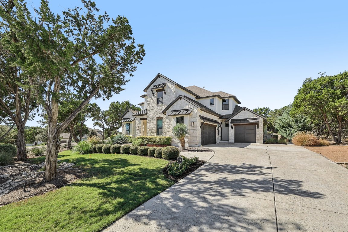 19316 Splendor Court Jonestown, TX 78645 - Photo 2 of 40 a front view of a house with a yard and trees