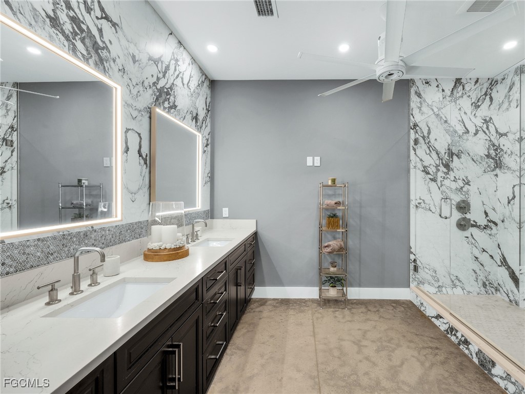 4412 Pinetree Boulevard St. James City, FL 33956 - Photo 30 of 50 a bathroom with a double vanity sink and a mirror
