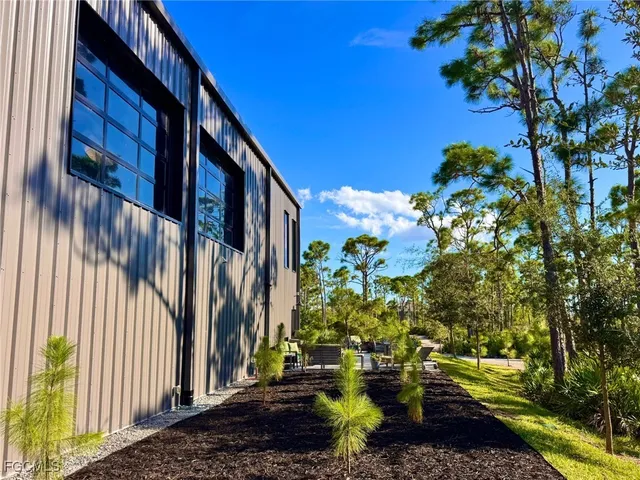 an aerial view of residential house with outdoor space and trees all around