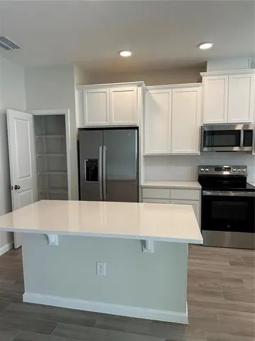 a room with wooden cabinets and stainless steel appliances