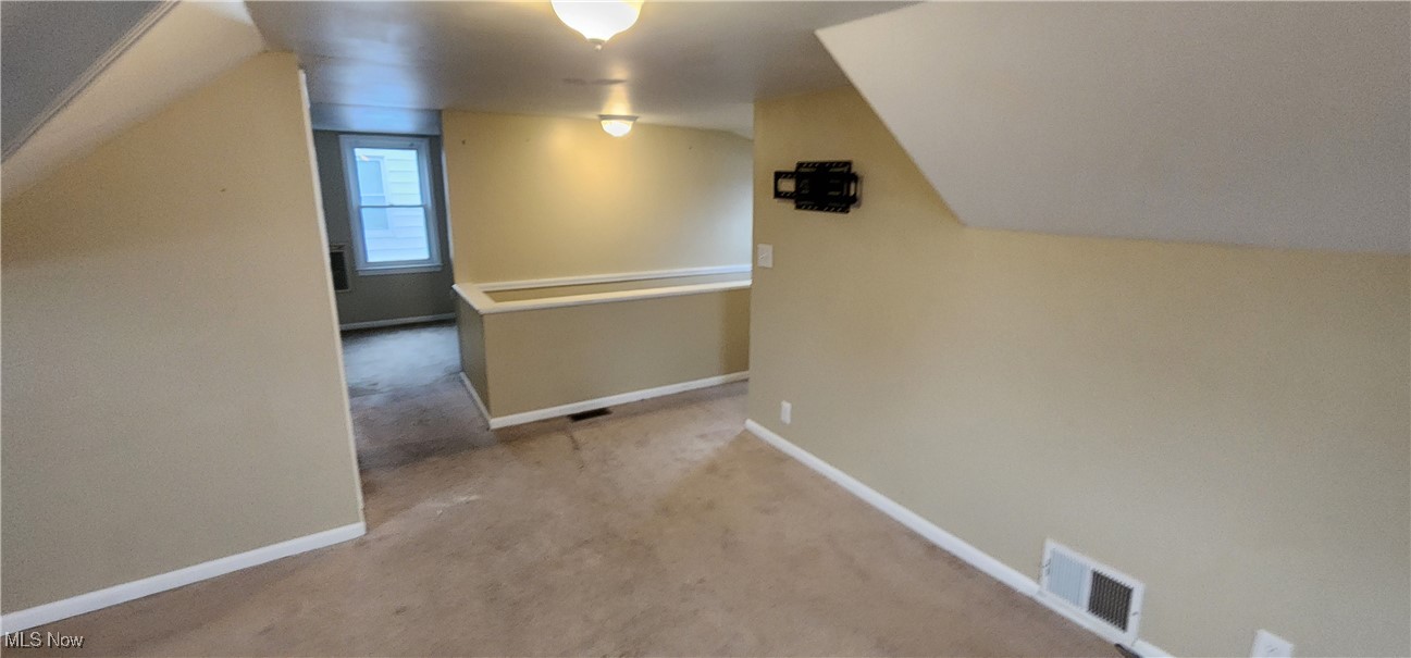 4161 Lambert Road Cleveland, OH 44121 - Photo 13 of 18 Bonus room with light carpet and vaulted ceiling
