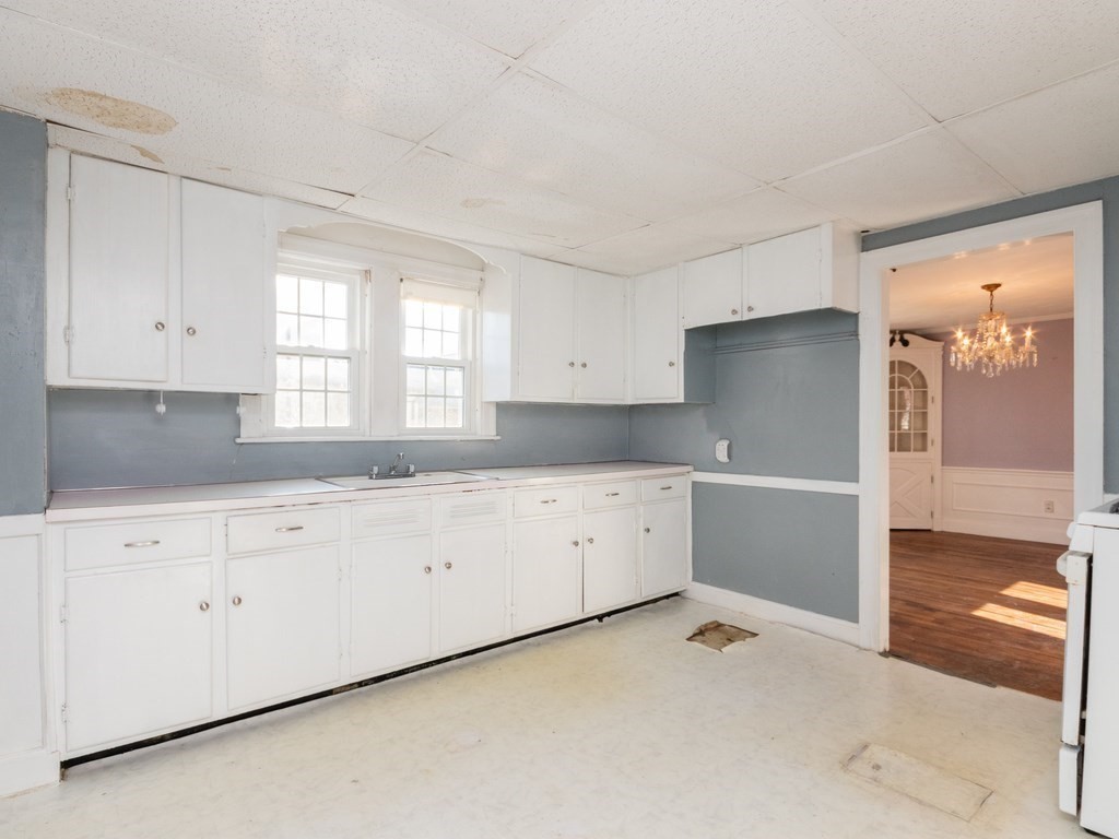 20 Ferncroft Road Boston, MA 02132 - Photo 3 of 40 a kitchen with granite countertop white cabinets white appliances a sink and a large window