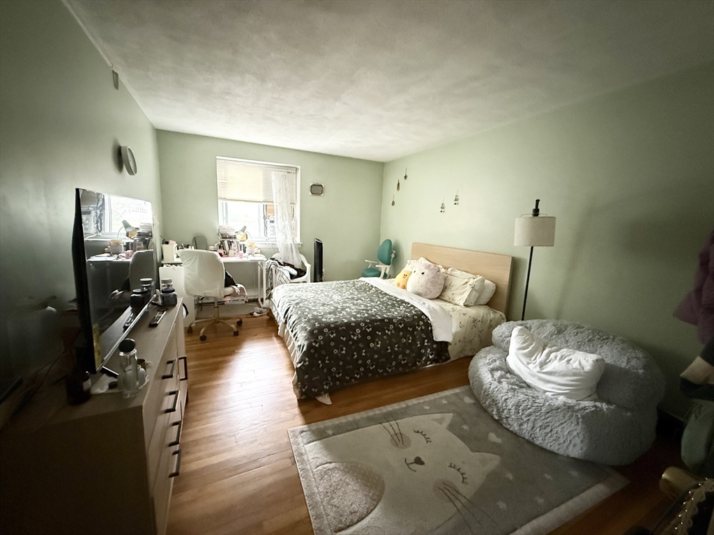 20 Radcliffe Road, Unit 206 Boston, MA 02134 - Photo 7 of 13 a bedroom with a bed and wooden floor