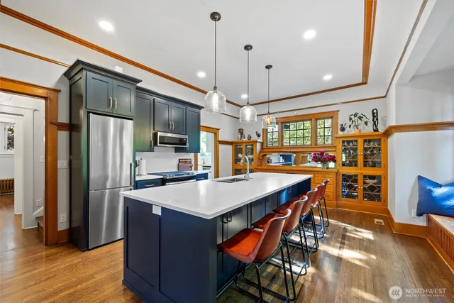 a kitchen with stainless steel appliances granite countertop a table chairs and a refrigerator