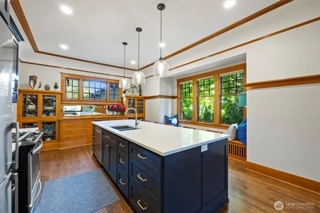 a kitchen with a stove and a wooden floor