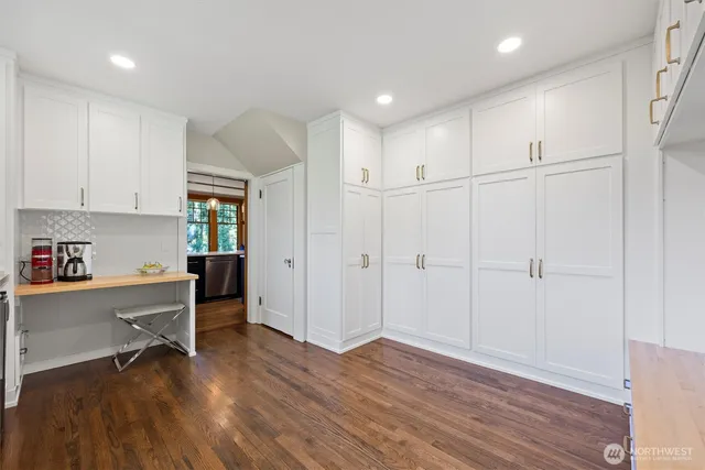 a view of a kitchen with wooden floor and a window
