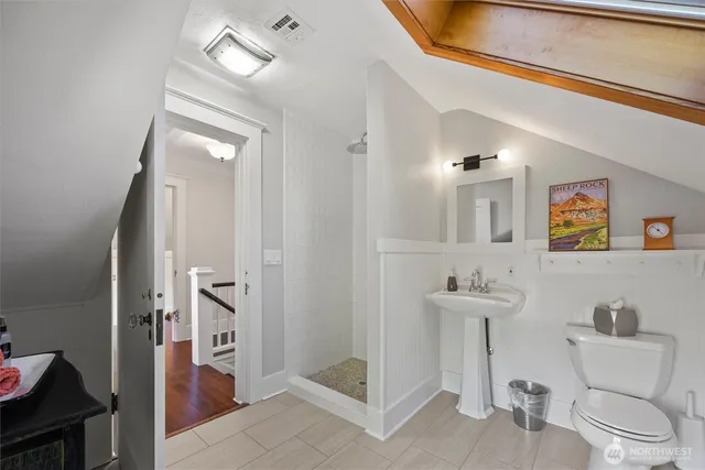 a bathroom with a toilet a sink and mirror