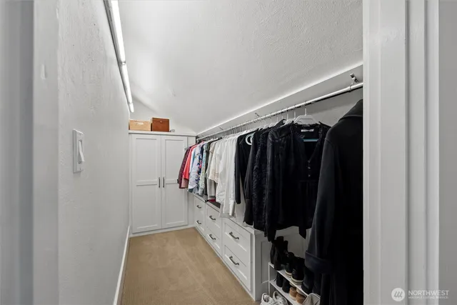 a view of walk in closet with clothes