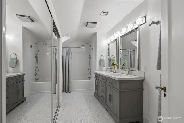 a bathroom with a double vanity sink mirror and shower