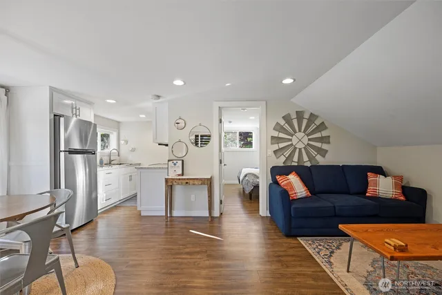 a view of a roof deck with table and chairs couches with wooden floor and fence
