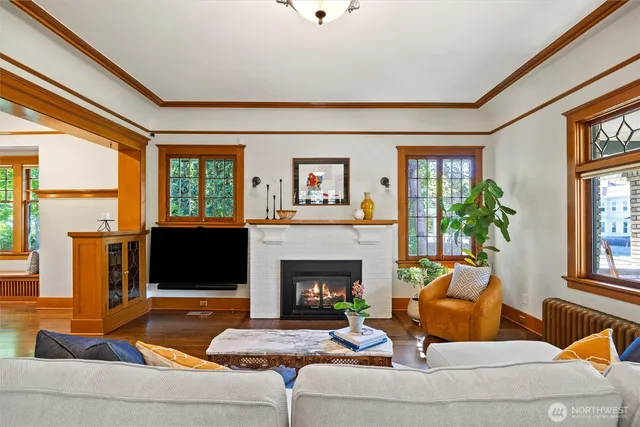 a living room with furniture a fireplace and a large window