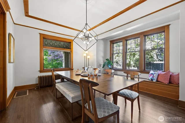 a dining room with wooden floor a chandelier a glass table and chairs