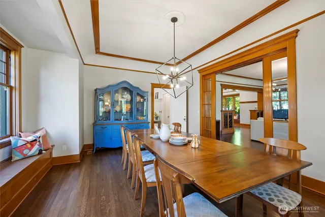 a dining room with furniture a chandelier and wooden floor