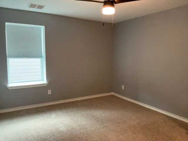 an empty room with windows and closet