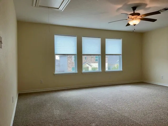 a view of an empty room with a chandelier fan