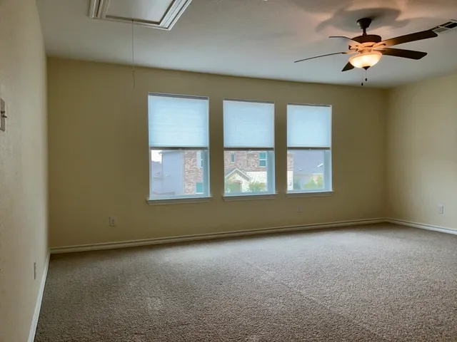 a view of an empty room with a chandelier fan