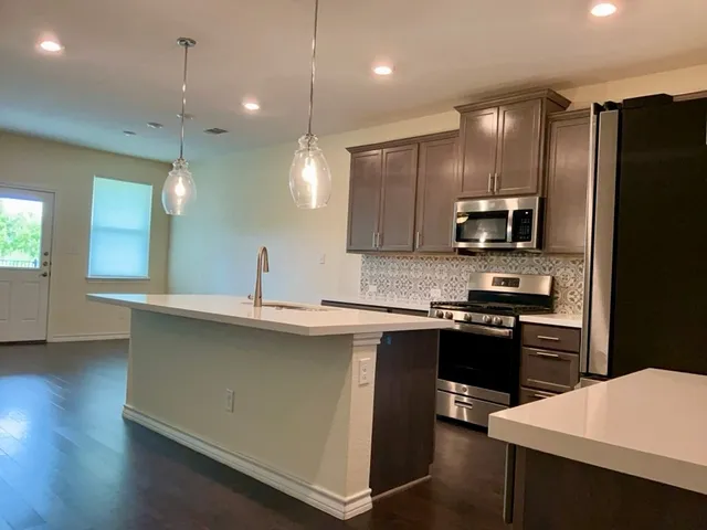 a kitchen with kitchen island a sink stove and refrigerator