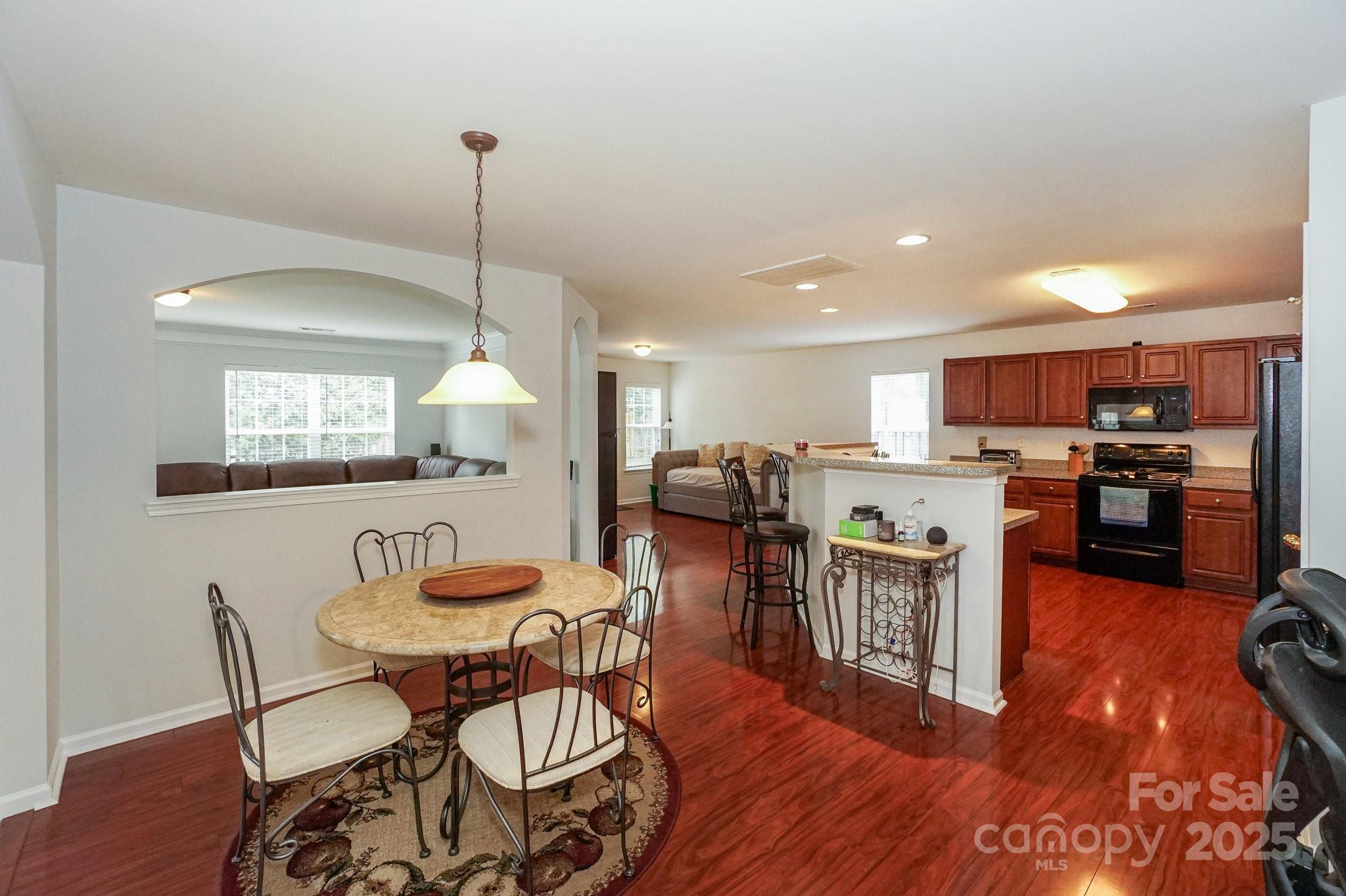 166 Glennallen Road Mooresville, NC 28115 - Photo 12 of 48 a kitchen with stainless steel appliances kitchen island granite countertop a table chairs and a refrigerator