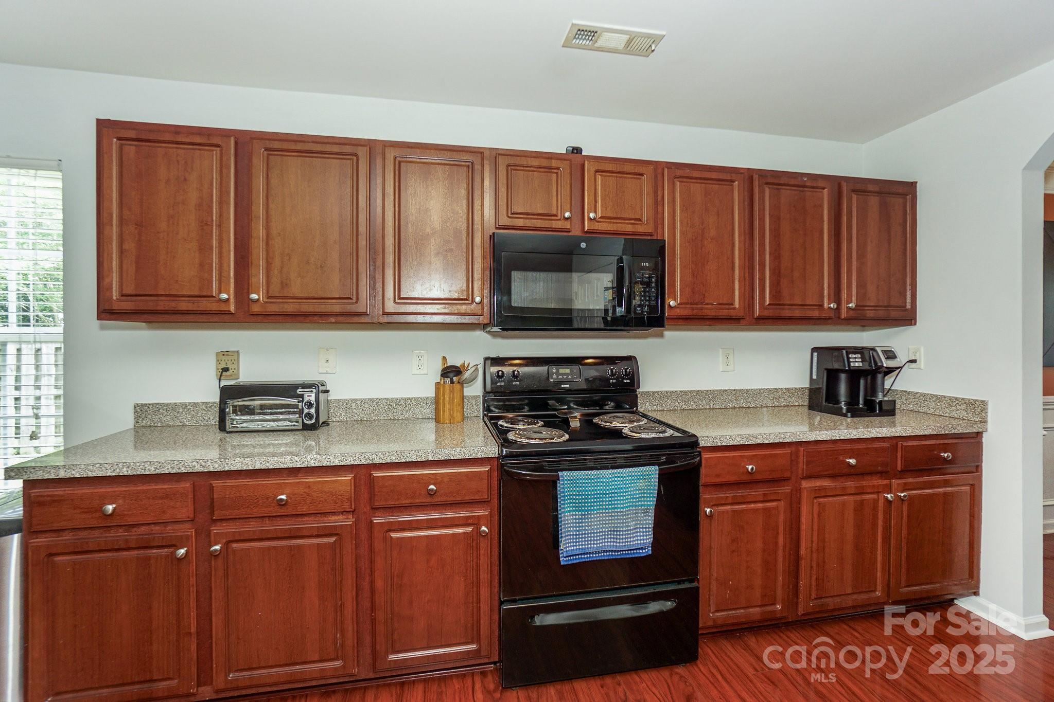 166 Glennallen Road Mooresville, NC 28115 - Photo 14 of 48 a kitchen with granite countertop wooden cabinets and a stove top oven