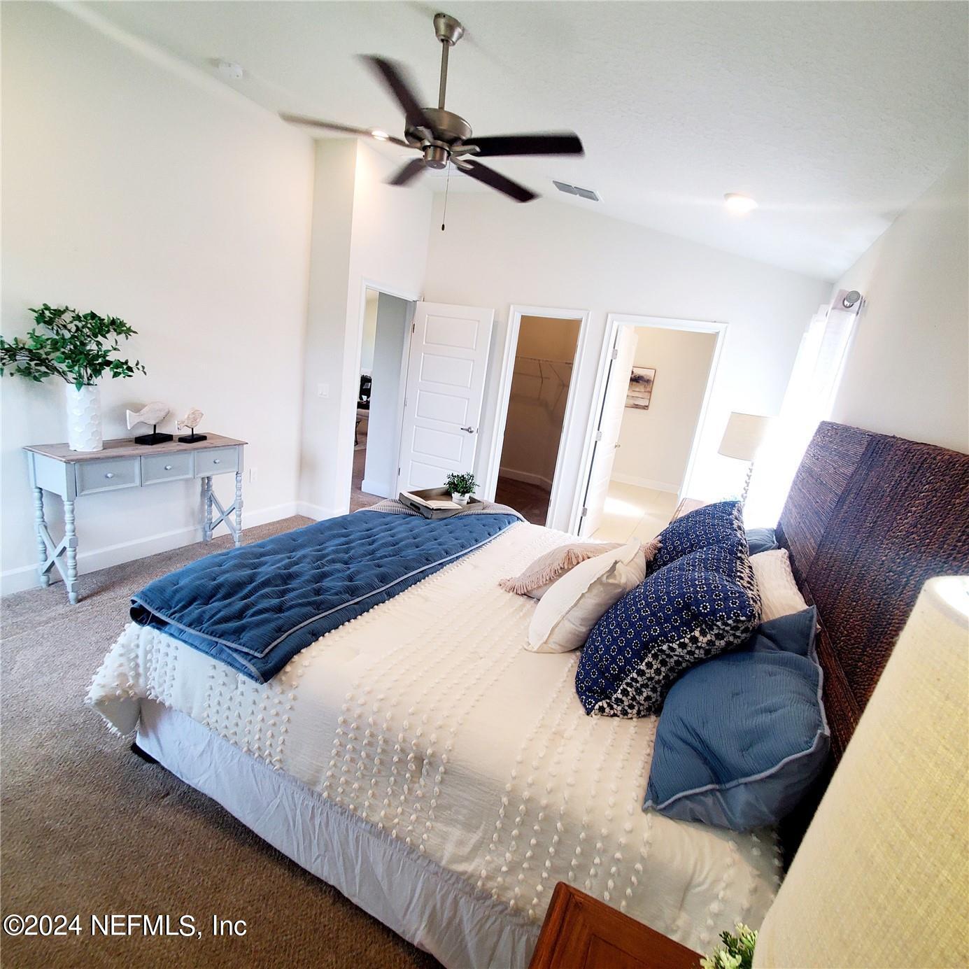 70 Rivertown Road Palm Coast, FL 32137 - Photo 15 of 25 a bedroom with a large bed and a chandelier