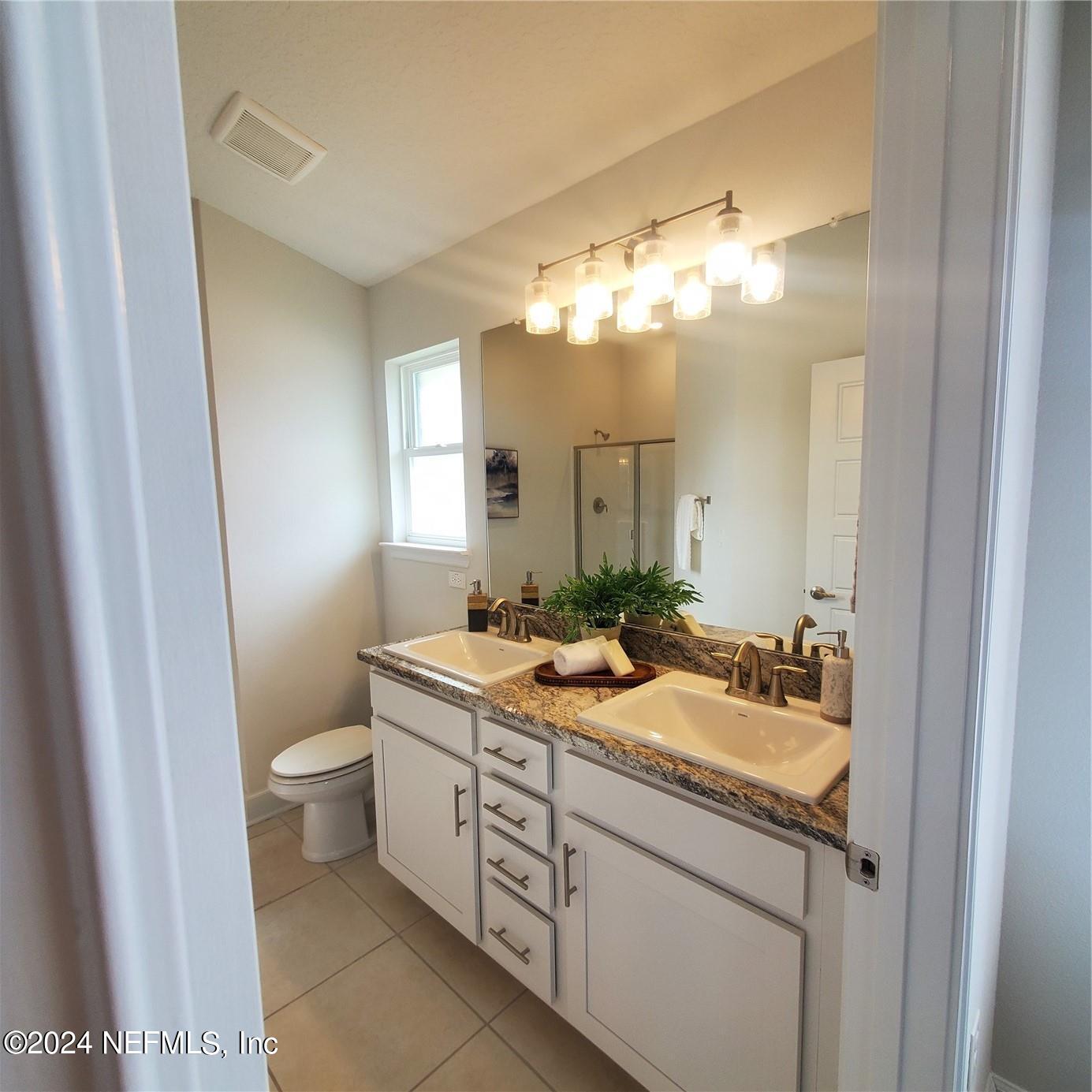70 Rivertown Road Palm Coast, FL 32137 - Photo 18 of 25 a bathroom with a double vanity sink and a mirror