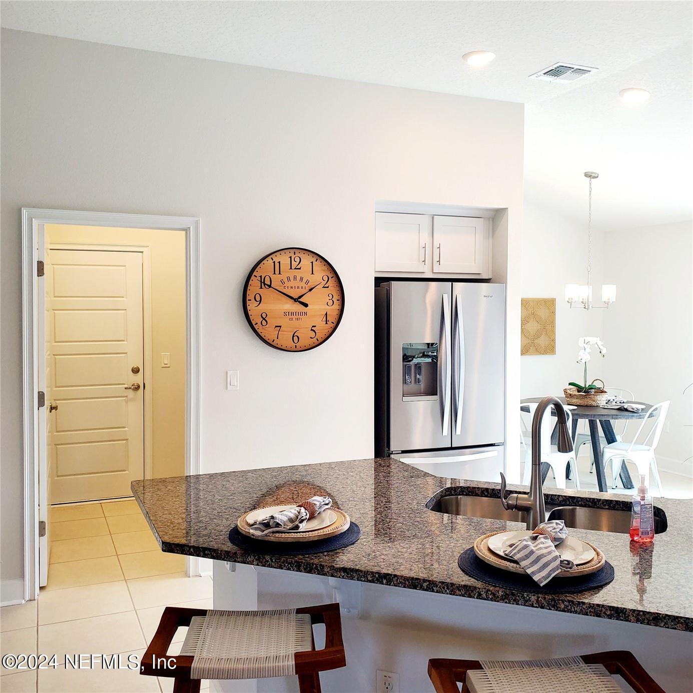 70 Rivertown Road Palm Coast, FL 32137 - Photo 6 of 25 a table with a stove and a white cabinet with wooden floor
