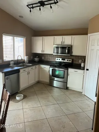 a kitchen with stainless steel appliances a sink a stove top oven a counter space and cabinets