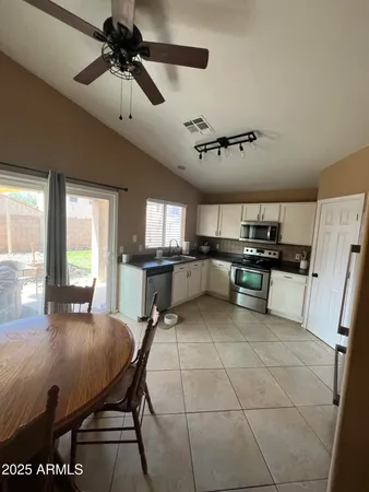 a room with stainless steel appliances lots of counter space and dining table